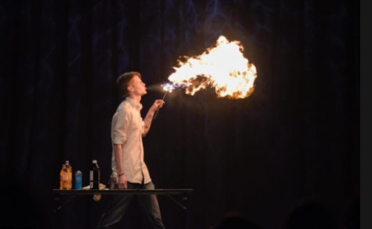 Gutt som blåser flammer