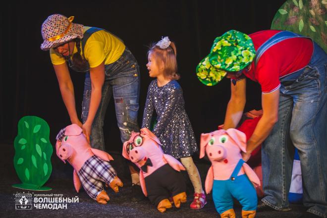 Voksne og barn på scena med dukker